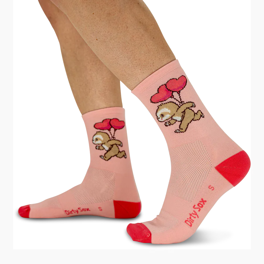 Hellrosa Laufstrümpfe an den Beinen einer Person. Auf jeder Socke ein comicartiges, schnell rennendes Faultier mit drei roten Herzballons am Rücken. Zehen und Fersen leuchtend rot, Stoff atmungsaktiv. "DirtySox" Logo sichtbar.