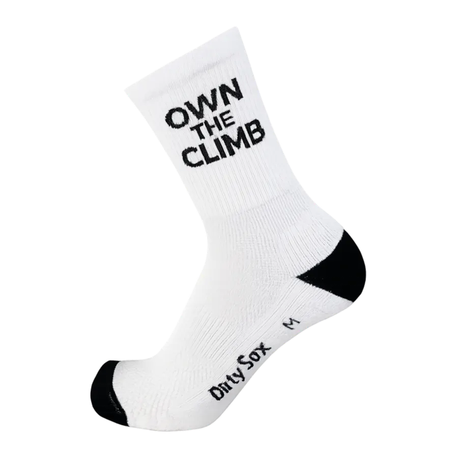 Weißer Sportsocken mit schwarzer Schrift: "OWN THE CLIMB" am Schaft. Ferse und Zehen schwarz abgesetzt. Seitlich am Fuß "Dirty Sox" und Größe "M". Ideal für Läufer und Kletterer.