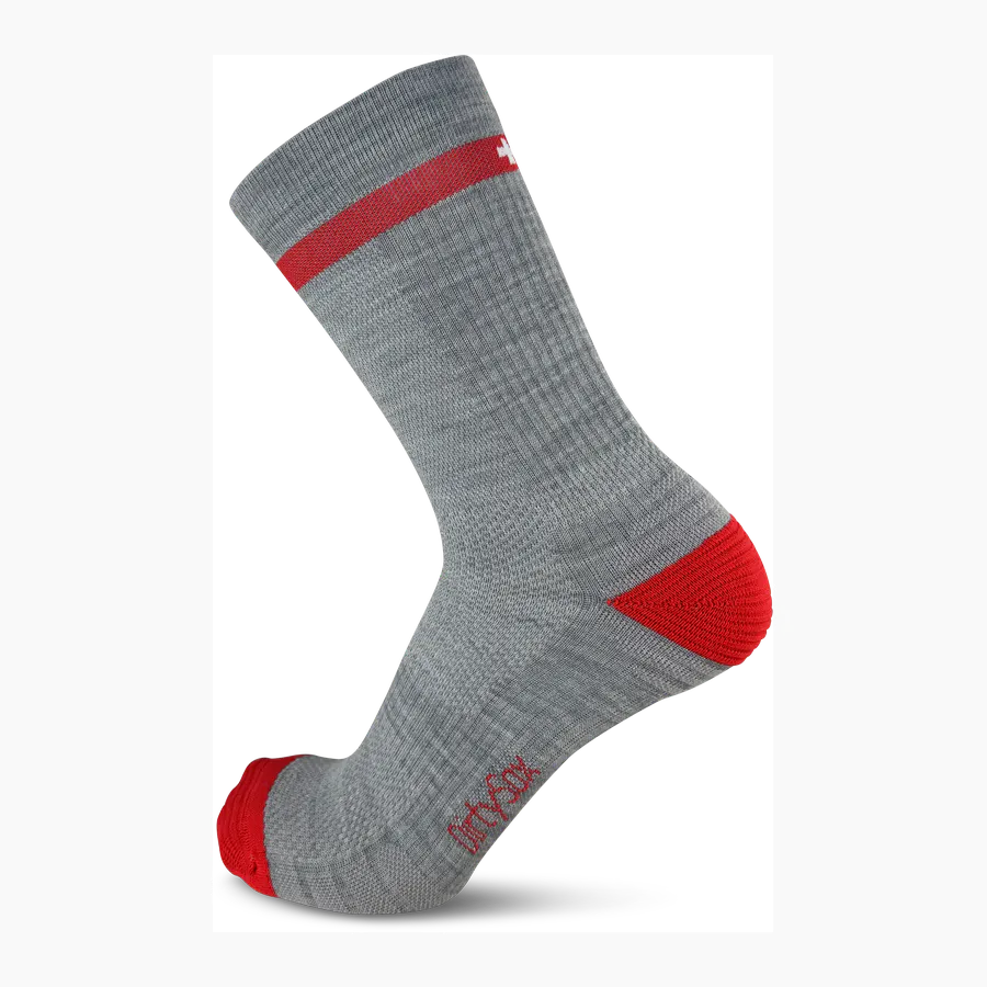 Grey merino wool trekking socks with a red heel and toe section. A red stripe featuring the white Swiss cross runs along the leg. The ‘ DirtySox ’ logo is embroidered in red on the side. Sturdy knitted fabric designed for outdoor use.